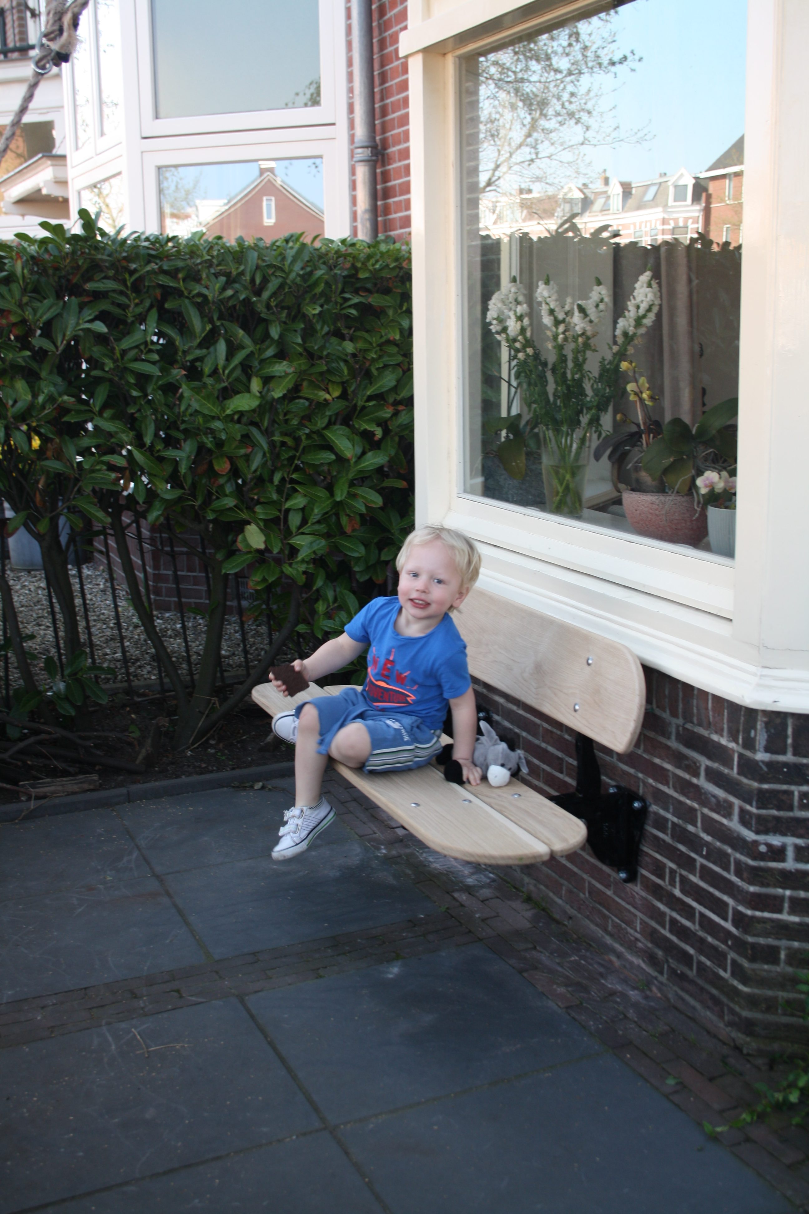 Best hoog; we kunnen het bankje ook lager ophangen;) jongetje zit op Amsterbankje